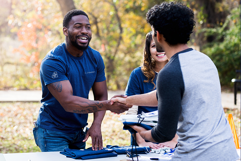 Mid adult man shakes hands with volunteer